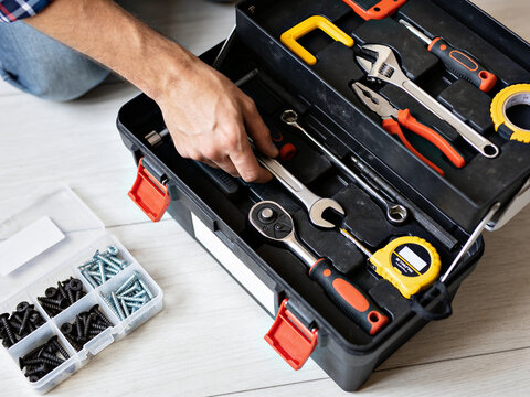 Top View of Open Toolbox with Furniture Assembly Tools and Hand Returning Screwdriver