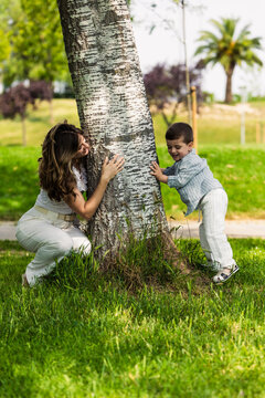 Mother and son playing hide and seek in park