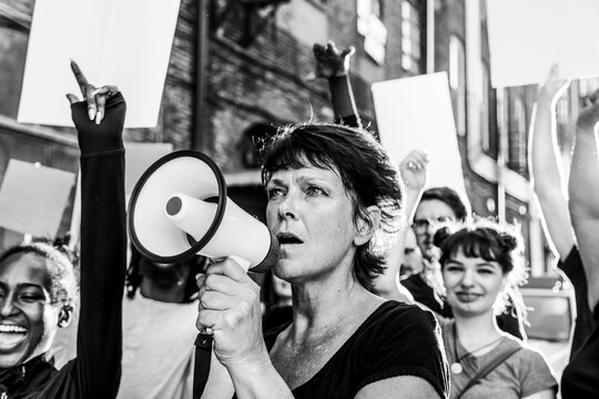 Protest crowd with woman speaking through megaphone