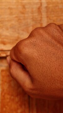 Close up of a hand knocking on an old wooden door, visitor arrival and hospitality home entrance concept.