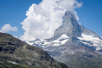 Fototapeta premium Matterhorn peak with cumulus clouds in summer telephoto view
