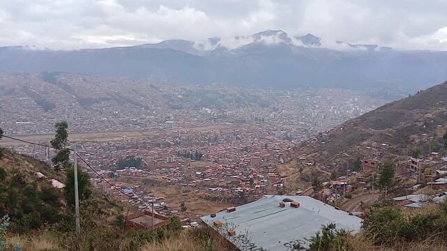 A scene featuring an upward-tilting shot that reveals the landscape, showing mountains and the city in the background.