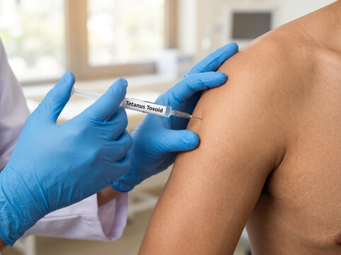 Medical doctor administering a tetanus toxoid booster shot
