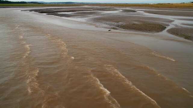 Tidal water moving past mudflats