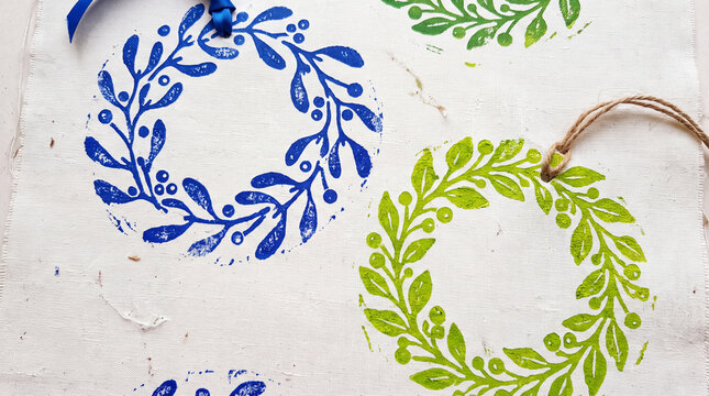 cobalt blue mistletoe and lime green wreaths hand stamped from fresh potato wedges onto pure white flax canvas displaying subtle woodblock like printing flaws