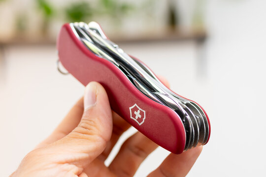 ZAPOPAN, MEXICO - SEPTEMBER 11, 2026: Hand holding a red Victorinox WorkChamp pocket knife.