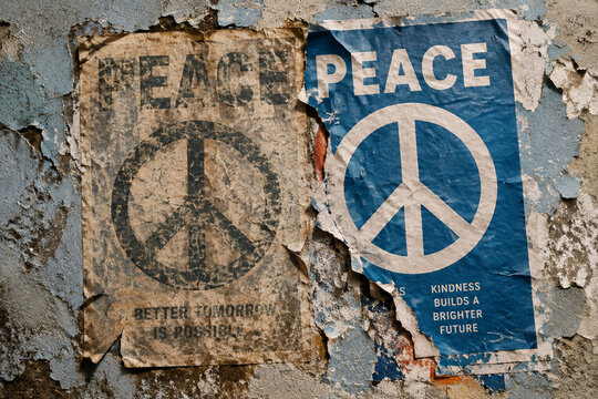 Weathered Peeling Wall With Two Overlapping Peace Posters One Old And Faded