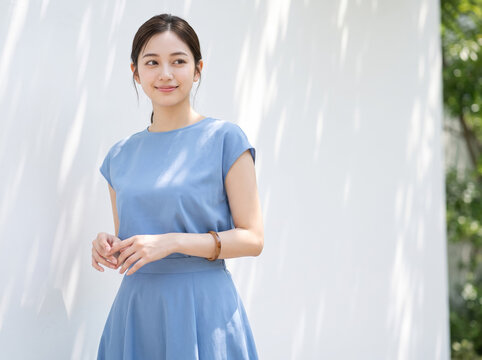 青いドレスを着て爽やかに微笑む女性