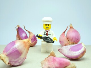 Fototapeta premium Indonesia - November 16, 2023 : Mini toy figure at table with blurred background. Chef concept design. Miniature photography.