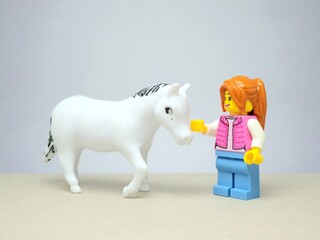 Fototapeta premium Indonesia - December 1, 2023 : Mini toy figure of people at table with blurred background. Miniature photography concept design. Horse Jockey concept.