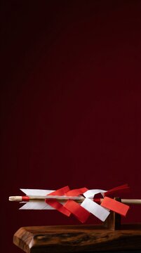 Shinto sacred blessing arrow hamaya with red and white shide paper on wooden stand vertical