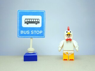 Fototapeta premium Indonesia - March 25, 2024 : Mini toy of action figure at table with blurred background. Miniature photography concept. Bus stop conceptual design.