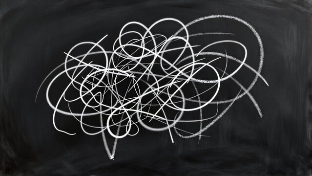 Chalk scribbles on blackboard, tangled loops and circles in white.
