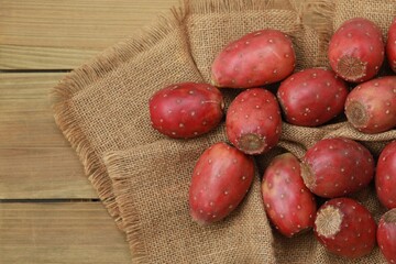 Fresh red prickly pear cactus fruits on burlap and wooden background © TETIANA 