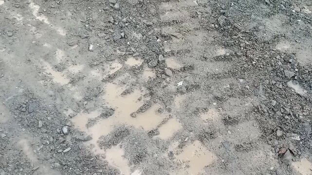 Wet Muddy Ground with Rocks and Puddles Nature Texture Background