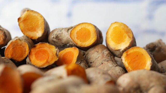 Close up footage of fresh turmeric root sliced showing vibrant orange color and texture