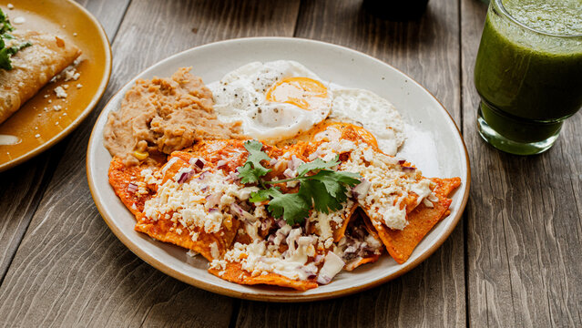 Mexican Chilaquiles Rojos with Fried Egg and Refried Beans