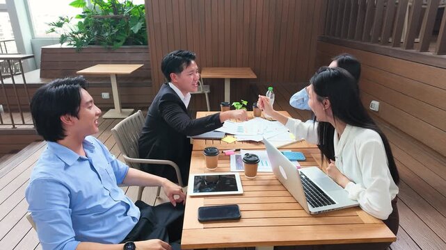 Asian Business Team Celebrating Success with High Fives on Office Terrace