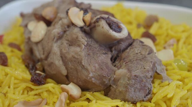Close up of traditional lamb mandi with rice and cashews served in a plate
