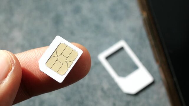 Close up slow motion of hand holding a micro SIM card, concept of cellular technology communication