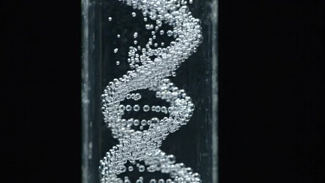 Thousands of tiny silver bubbles spiral upward through clear liquid in the precise shape of a twisting double helix. Genetics and molecular science