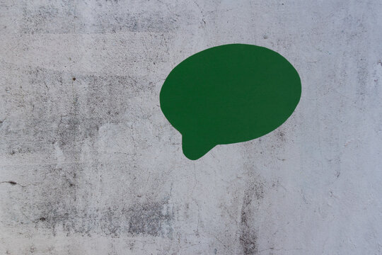 Green speech bubble on weathered concrete background
