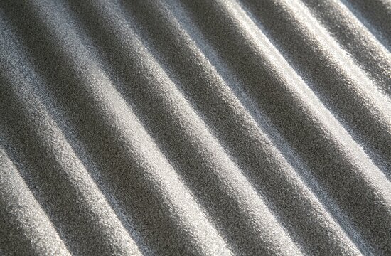 Close-up textured surface with parallel ridges casting soft shadows