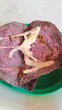 Person Unfolding Red Homemade Tortilla Served on Green Plate with Oaxaca Cheese