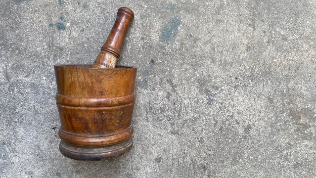 Traditional Old Wooden Mortar and Pestle on Gray Concrete Floor Background Top View