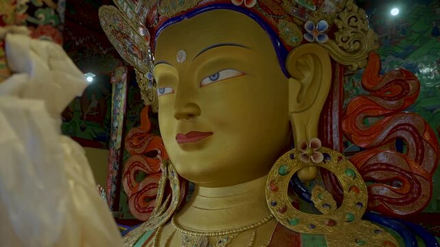 Intricately decorated Buddhist statue inside a traditional monastery in Ladakh, India. The colorful sacred figure, adorned with ornate jewelry and a ceremonial crown, reflects Tibetan Buddhist culture