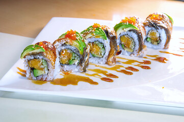Gourmet Eel and Avocado Sushi Rolls on White Plate © DinhThi