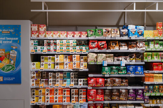 August 20, 2026, Amsterdam, Netherlands - Supermarket aisle displaying various coffee and tea products from brands like Douwe Egberts, Starbucks, and Senseo