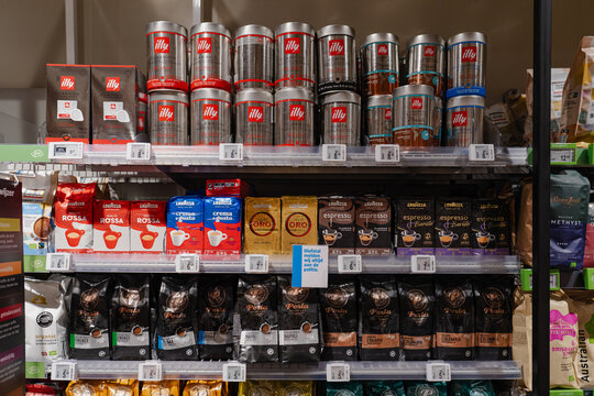 August 20, 2026, Amsterdam, Netherlands - Shelves stocked with various coffee brands like Illy, Lavazza, and Perla in a supermarket