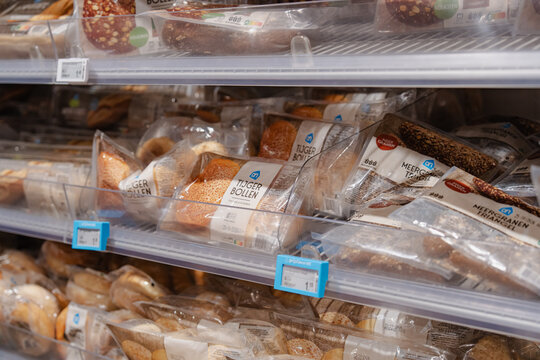 August 20, 2026, Amsterdam, Netherlands - Packaged bread products, including "Tijger Bollen" and "Meergranen Triangel", on display shelves at an Albert Heijn supermarket