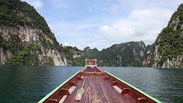 Longtail boat cruising through cheow lan lake in khao sok national park