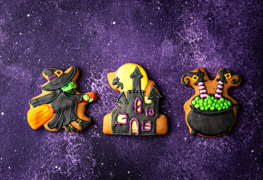Spooky Halloween cookies shaped like witch cauldron and haunted manor