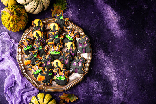 Spooky Halloween cookies shaped like witch cauldron and haunted manor