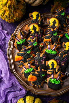 Spooky Halloween cookies shaped like witch cauldron and haunted manor