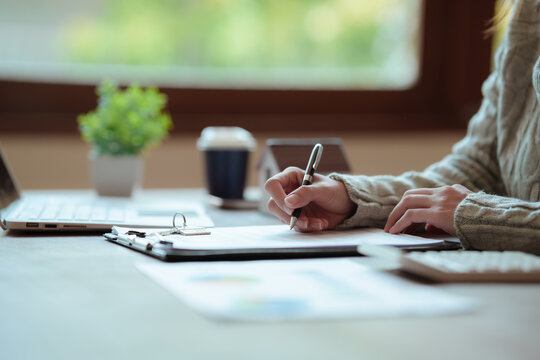 A real estate professional reviews and signs a property agreement, representing a home purchase, mortgage approval, investment, and legal transaction.