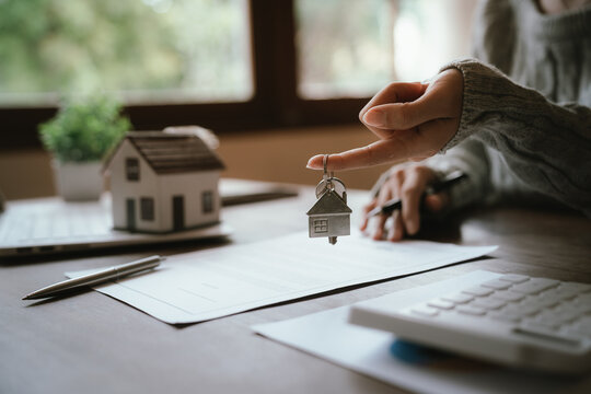 A real estate professional reviews and signs a property agreement, representing a home purchase, mortgage approval, investment, and legal transaction.