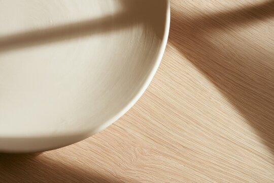 Bowl placed on wooden surface with shadow patterns during morning light