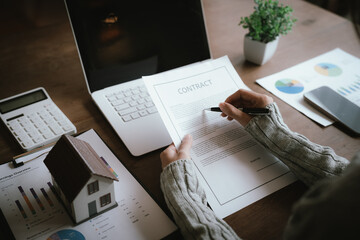 A real estate professional reviews and signs a property agreement, representing a home purchase,...