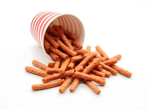 Spilled snack food chips in striped paper cup with white background for packaging design
