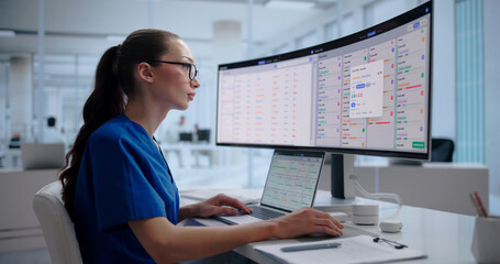 Healthcare Manager Reviews Patient Data On Laptop