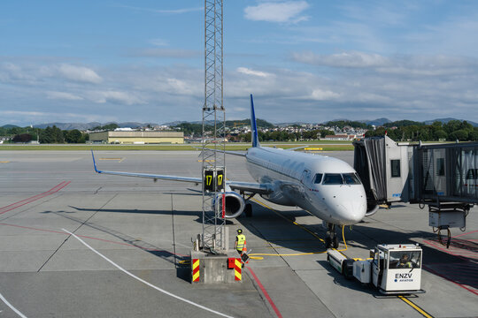 August 19, 2026, Stavanger, Norway - An airplane parked at gate 17 with ground crew and pushback tug at Stavanger Airport Sola