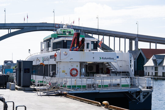 August 19, 2026, Haugesund, Norway - Kolumbus electric ferry Fjords&oslash;y docked and charging at the harbor with a bridge in the background