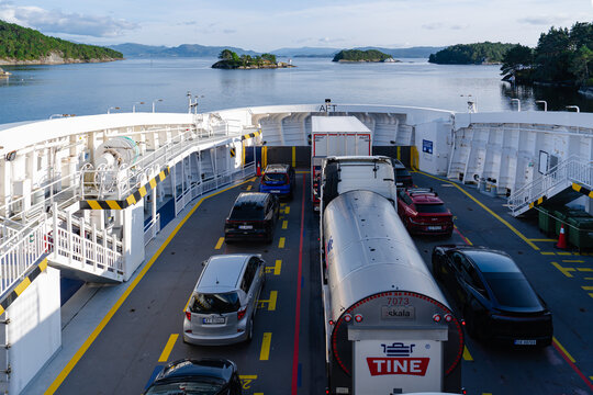August 19, 2026, Halhjem, Norway - Vehicles including cars and TINE trucks loaded on a ferry in a fjord