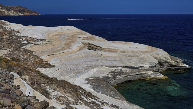 Wavy, bright limestone slab next to the blue sea coast, white volcanic strata, bizarre white rocks in the sea, Little Sarakiniko, Kioni Beach, Kioni, Kimolos Island, Cyclades, Greek Islands, Greece