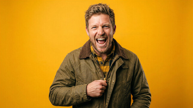 Man unzipping jacket with excited expression against yellow background