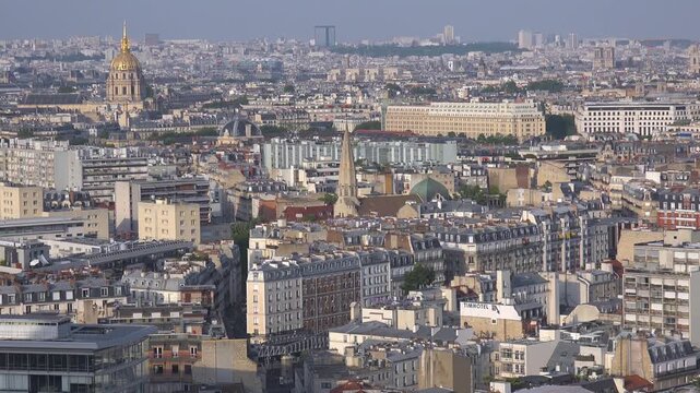 Panoramic view of Paris city skyline featuring golden dome of Les Invalides under clear sky.